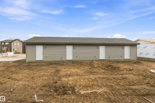 Building with gray horizontal siding and a dark shingle roof - 7097 Rosenthal Drive Nw, Edmonton, AB 