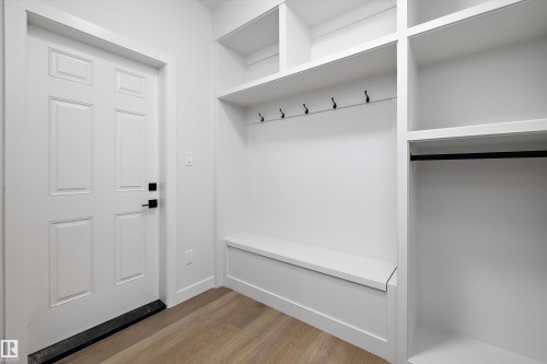 Built-in shelving with storage bench, wall-mounted hooks, and clothing rod - 1780 Crossbill Loop Nw, Edmonton, AB 
