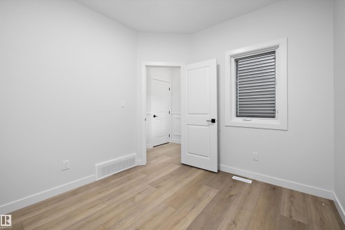 Light wood-finish flooring, white trim, and a window with horizontal blinds - 1780 Crossbill Loop Nw, Edmonton, AB 
