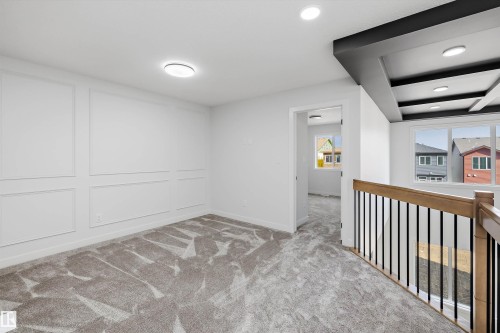Wall paneling accent, recessed lighting, carpeted flooring, wood-finish handrail, black metal balusters - 1780 Crossbill Loop Nw, Edmonton, AB 