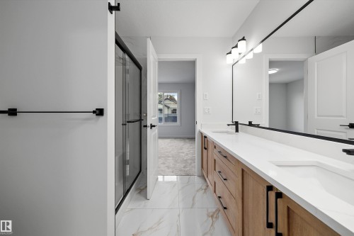 Dual vanity with undermount sinks, wood-finish cabinetry, and white countertops - 1780 Crossbill Loop Nw, Edmonton, AB 