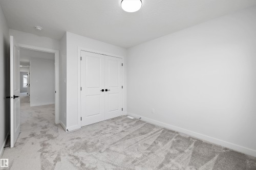 Neutral wall finishes, recessed lighting fixture, paneled closet doors with dark hardware, and light-toned carpeting - 1780 Crossbill Loop Nw, Edmonton, AB 