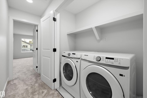 Dedicated laundry area featuring a built-in shelf, white paneled doors with dark hardware, and recessed lighting - 1780 Crossbill Loop Nw, Edmonton, AB 