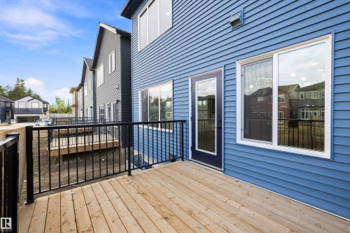 Expansive rear deck with wood-finish decking and black metal railings - 1780 Crossbill Loop Nw, Edmonton, AB 