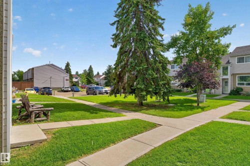 Expansive green spaces with mature trees, established concrete pathways, and dedicated parking areas - 18319 93 Avenue Nw, Edmonton, AB 