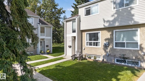 Two-story exterior with light-colored siding and stucco finishes, featuring multiple windows and a front entry - 18319 93 Avenue Nw, Edmonton, AB 