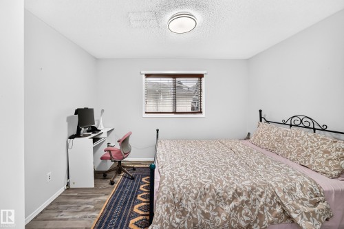 Wood-finish flooring with light gray walls, a window with wood-finish blinds, and a flush mount ceiling light - 4216 47 Street Nw, Edmonton, AB 