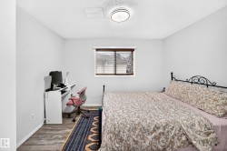 Wood-finish flooring with light gray walls, a window with wood-finish blinds, and a flush mount ceiling light - 