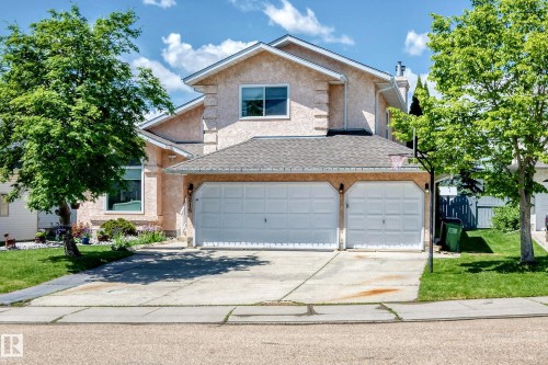 Stucco exterior with a peaked roofline, featuring a two-car attached garage and a concrete driveway - 4216 47 Street Nw, Edmonton, AB 