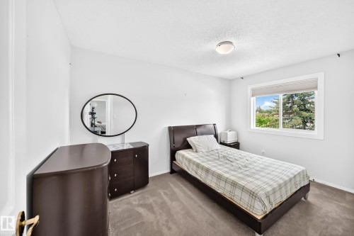 White walls with a textured ceiling, a window with a roller shade, and gray carpet - 4216 47 Street Nw, Edmonton, AB 
