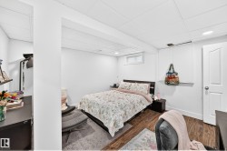 Wood-finish flooring, white walls, and a drop ceiling with recessed lighting - 