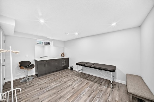Wood-finish flooring, recessed lighting, built-in cabinetry with a white countertop, and a window - 4216 47 Street Nw, Edmonton, AB 