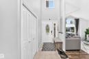 Double bifold closet doors, tile flooring, decorative front entry door with sidelight, and a vaulted ceiling - 4216 47 Street Nw, Edmonton, AB 