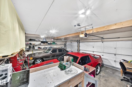 Two-car garage featuring automatic garage door openers, overhead lighting, concrete flooring, and built-in shelving - 4216 47 Street Nw, Edmonton, AB 
