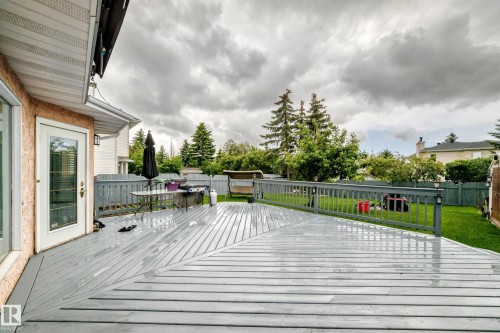 Expansive deck with multi-directional planking, durable railing, and direct access to a manicured lawn - 4216 47 Street Nw, Edmonton, AB 