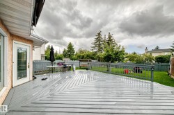 Expansive deck with multi-directional planking, durable railing, and direct access to a manicured lawn - 