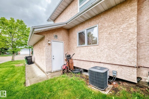 Stucco exterior with a single-pane window and an air conditioning unit - 4216 47 Street Nw, Edmonton, AB 