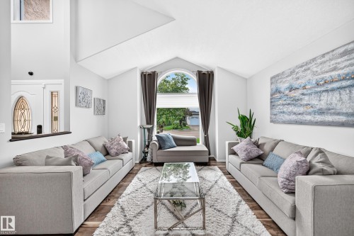 Vaulted ceilings with wood-finish flooring, an arched window, and a white interior paint scheme - 4216 47 Street Nw, Edmonton, AB 