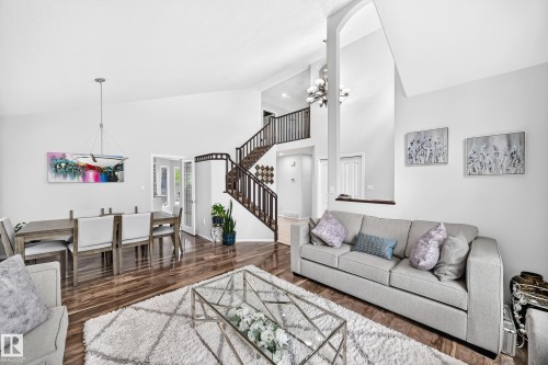 Vaulted ceilings, wood-finish flooring, and a formal dining area with a modern linear chandelier - 4216 47 Street Nw, Edmonton, AB 