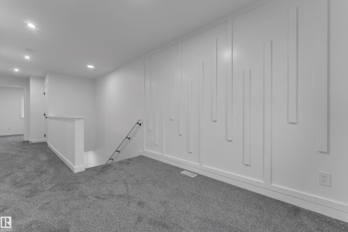 Recessed lighting, contemporary feature wall paneling, white painted railings, and gray carpet flooring - 265 Falcon Crescent, Leduc, AB 