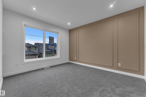 Recessed lighting, large window, patterned accent wall, light grey walls, and grey carpeting - 265 Falcon Crescent, Leduc, AB 