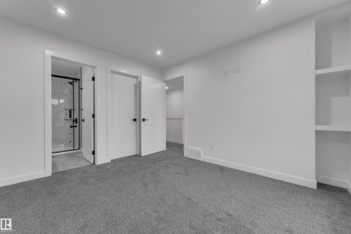 Gray carpeting with recessed lighting, built-in shelving, and white interior doors with black hardware - 265 Falcon Crescent, Leduc, AB 