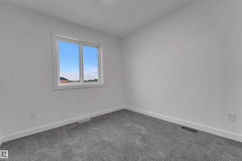 Neutral wall color, grey carpet flooring, and a double-pane window - 265 Falcon Crescent, Leduc, AB 