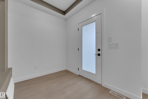 White interior door with frosted glass panel, recessed lighting, and wood-finish flooring - 265 Falcon Crescent, Leduc, AB 