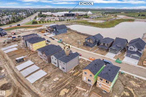Newly constructed residence with dark shingle roofing, light-toned siding, and an attached garage - 265 Falcon Crescent, Leduc, AB 