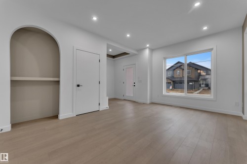 Recessed lighting, light wood-finish flooring, white walls, arched alcove, and a large window - 265 Falcon Crescent, Leduc, AB 