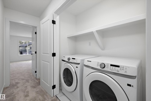 Convenient laundry area with built-in shelving, white appliances, and a tile floor - Edmonton, AB 