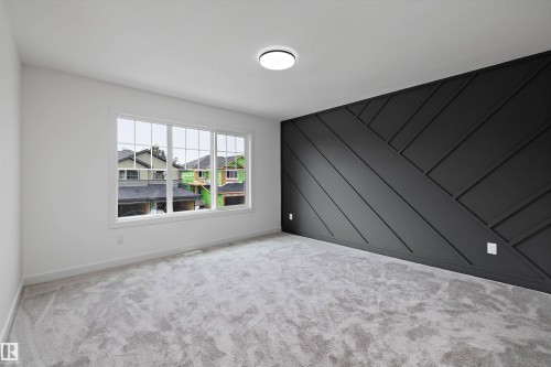 Accent wall with geometric paneling, expansive window with white trim, flush-mount ceiling light, and light-toned carpeting - Edmonton, AB 