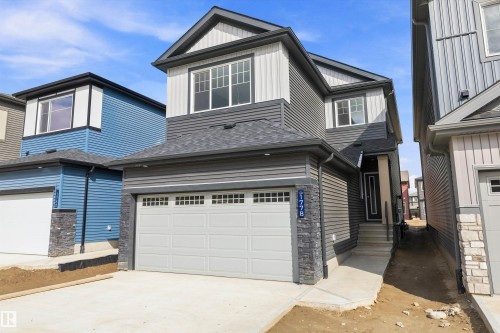 Two-story residence featuring a two-tone facade with dark grey horizontal siding and light grey vertical siding - Edmonton, AB 