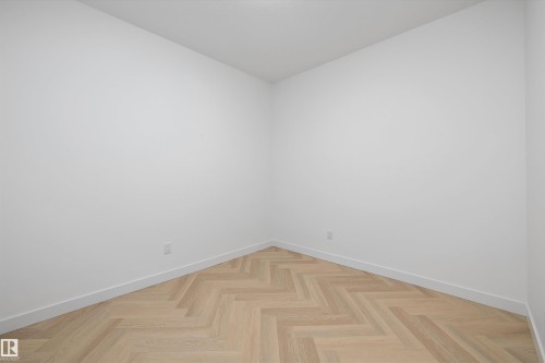 Herringbone wood-finish flooring, white walls, and bright overhead lighting - Edmonton, AB 