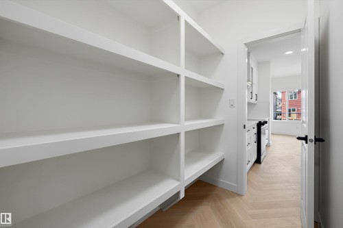 Built-in shelving, white walls, and wood-finish herringbone flooring - Edmonton, AB 