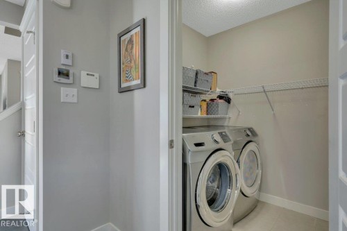 Main floor laundry with ample storage and shelving - 160 Desrochers Gate Sw, Edmonton, AB 