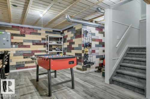 With vinyl plank flooring, wood-slat suspended ceilings and decorative wood plank walls - 160 Desrochers Gate Sw, Edmonton, AB 