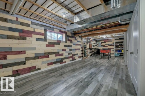 With vinyl plank flooring, wood-slat suspended ceilings and decorative wood plank walls - 160 Desrochers Gate Sw, Edmonton, AB 