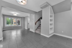Spacious open-concept area featuring large format tile flooring and a prominent window - 