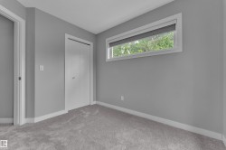 Soft gray walls complement the plush gray carpeting in this room featuring a horizontal window and a white bi-fold closet door - 