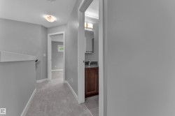Interior hallway with neutral gray walls, light gray carpeting, and white trim - 