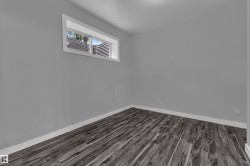 Room featuring wood-finish flooring, light gray wall paint, and white baseboards - 