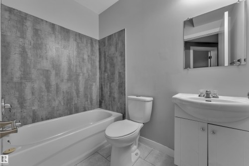 Bathroom featuring a white bathtub, toilet, and vanity with an integrated sink - 12221 117 Avenue Nw, Edmonton, AB - Indoor Photo Showing Bathroom