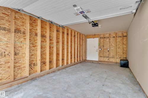 Garage interior featuring exposed wood framing and concrete flooring - 12221 117 Avenue Nw, Edmonton, AB - Indoor Photo Showing Garage