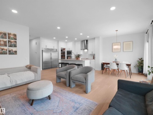 Open-concept living space featuring wood-finish flooring, recessed lighting, and a white color palette - 22650 99A Avenue Nw, Edmonton, AB - Indoor Photo Showing Living Room
