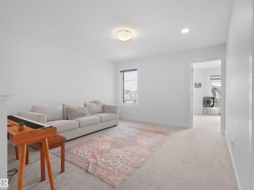 Bright interior space featuring light-colored carpeting, a window with white trim, a flush-mount ceiling light fixture, and an additional recessed light - 22650 99A Avenue Nw, Edmonton, AB - Indoor Photo Showing Living Room