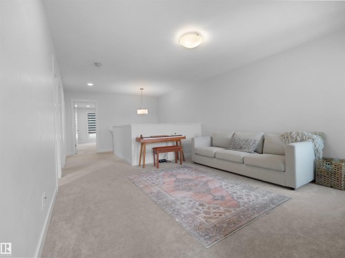 Spacious loft area featuring light-toned carpeting, white walls, and a contemporary flush-mount ceiling light - 22650 99A Avenue Nw, Edmonton, AB - Indoor