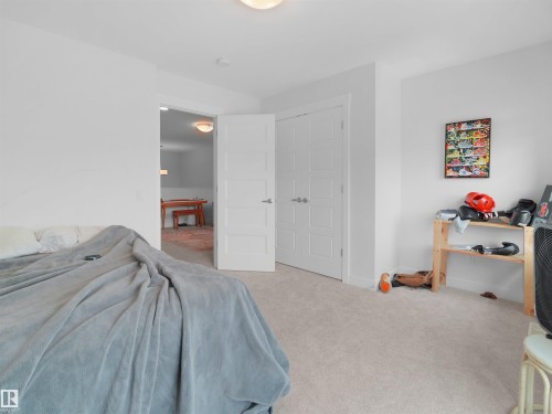 Carpeted room featuring a white paneled door, a standard white door, and neutral-colored walls - 22650 99A Avenue Nw, Edmonton, AB - Indoor Photo Showing Bedroom
