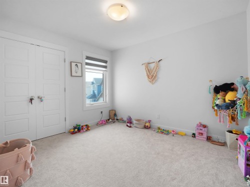 Bright room featuring light-colored carpeting, a window with horizontal blinds, and a flush-mount ceiling light - 22650 99A Avenue Nw, Edmonton, AB - Indoor