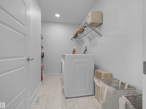 Dedicated laundry space featuring white paneled walls, recessed lighting, and light-toned tile flooring - 22650 99A Avenue Nw, Edmonton, AB - Indoor